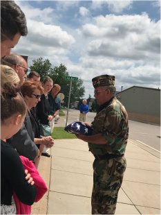 The commander of the Ely Honor Guard presents a flag to Mary Labernik.